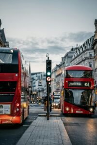 London cityscape featuring iconic double-decker buses on a bustling street at dusk.