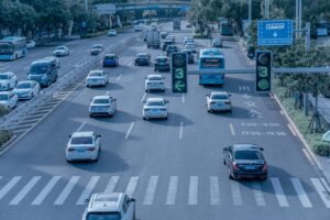 Wide shot of urban traffic at a busy city intersection with cars and buses.