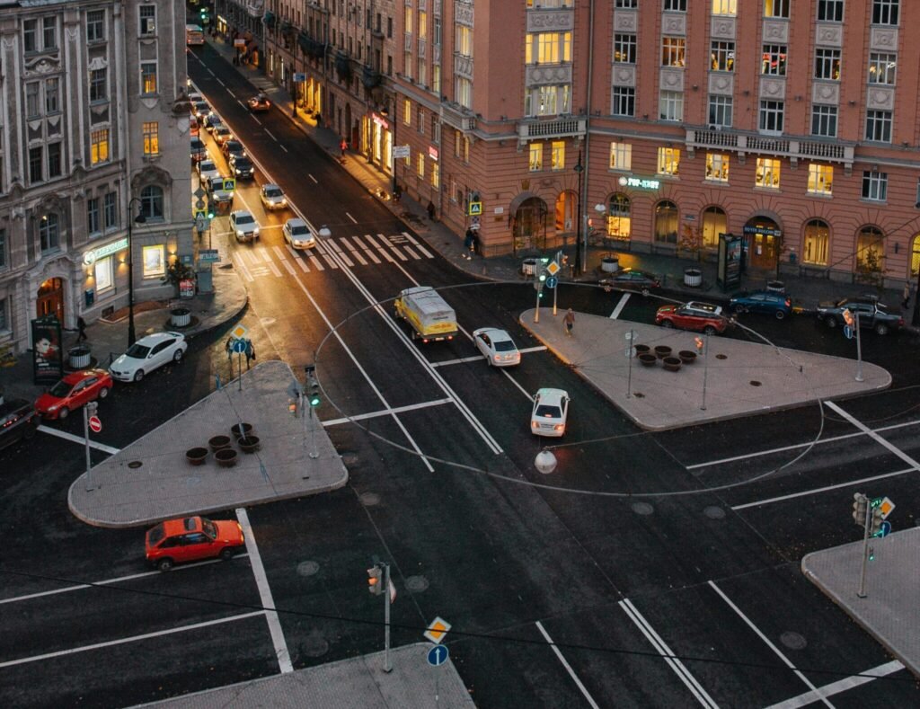 A vibrant city intersection with historic buildings at dusk, showcasing urban life.